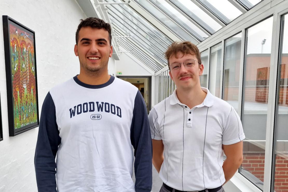 To finansbachelorer fra EAMV To glade yngre mænd foran vinduer